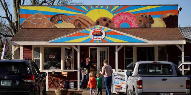 A family arrives at Leavitts Country Bakery, on April 13, 2023, in Conway, New Hampshire. The large painting created by students and displayed over the bakery is at the center of a legal battle pitting a zoning ordinance against freedom-of-speech rights. 