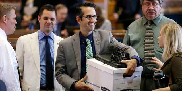 Rep. Joel Fry, center, carries a box from his desk on June 5, 2015, in Des Moines, Iowa. Thousands of Iowa residents would be expected to lose food stamp and Medicaid benefits under a bill given final legislative approval on April 13, 2023. Fry said the bill takes nothing away from people who are eligible for the benefits.