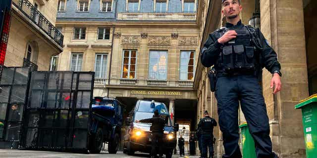 Police forces set up a barricade in front of the Constitutional Council on April 14, 2023, in Paris. The top constitutional body in France will rule on President Emmanuel Macrons' unpopular pension reform plan on April, 14, 2023.