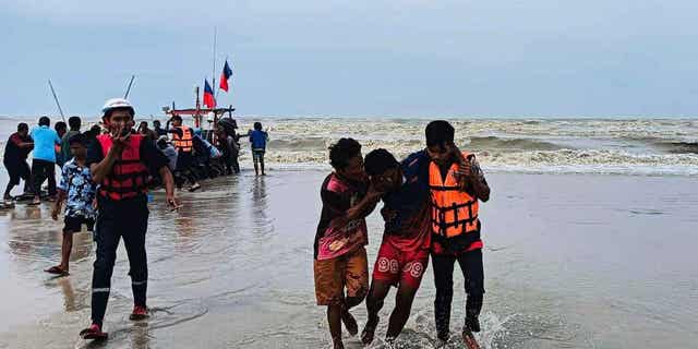 Rescuers from a charitable organization help a survivor from a boat that capsized off the coast of Nakhon Sri Thammarat province, Thailand, on April 16, 2023. A freak storm in Thailand killed three people and capsized a dozen boats.