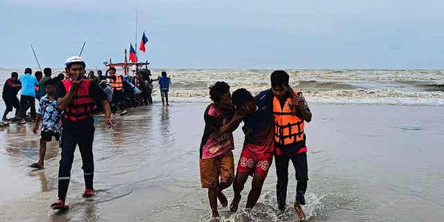 Rescuers from a charitable organization help a survivor from a boat that capsized off the coast of Nakhon Sri Thammarat province, Thailand, on April 16, 2023. A freak storm in Thailand killed three people and capsized a dozen boats.