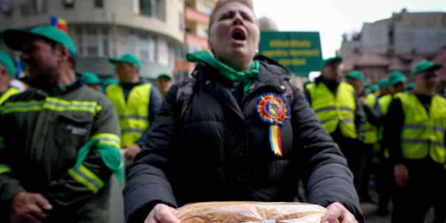 Eslovaquia, Polonia y Hungría prohíben la importación de alimentos de Ucrania, lo que genera objeciones de la Unión Europea 4 Una mujer sostiene una hogaza de pan durante una manifestación de agricultores en Bucarest, Rumania, el 7 de abril de 2023. Tres países de la Unión Europea impusieron una prohibición a las importaciones de alimentos de Ucrania.