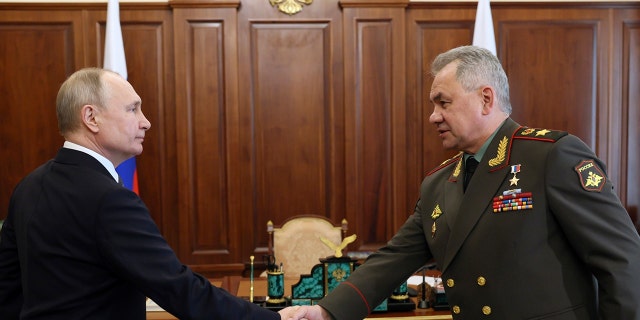 Russian President Vladimir Putin, left, and Russian Defense Minister Sergey Shoigu shake hands during their meeting in the Kremlin in Moscow, Russia on Monday, April 17, 2023. 