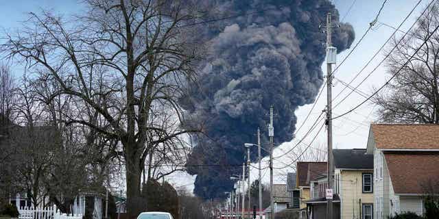 A black cloud of smoke rises over East Palestine, Ohio, as a result of a controlled detonation of a portion of the derailed Norfolk Southern trains, on Feb. 6, 2023. Alan Shaw, the CEO of Norfolk Southern, is set to testify before an Ohio Senate rail safety panel on April 18, 2023.