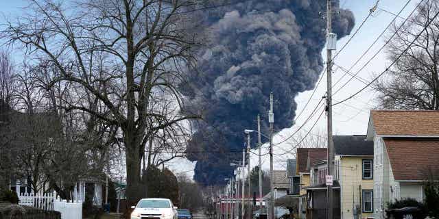 A black cloud of smoke rises over East Palestine, Ohio, as a result of a controlled detonation of a portion of the derailed Norfolk Southern trains, on Feb. 6, 2023. Alan Shaw, the CEO of Norfolk Southern, is set to testify before an Ohio Senate rail safety panel on April 18, 2023.