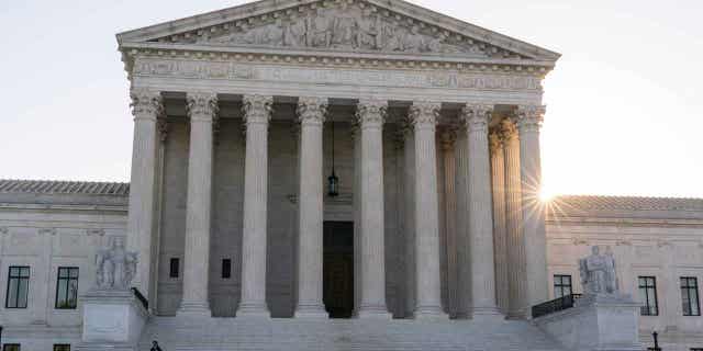 The sun rises behind the Supreme Court, on Oct. 11, 2022, in Washington. The Supreme Court decided New Jersey can withdraw from a commission created decades ago to combat the mobs influence at their joint port without New York's consent.