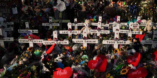 FLowers around crosses with naems of Uvalde shooting victims