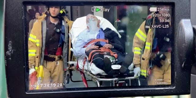 WARNING GRAPHIC IMAGE: FDNY personnel carry a person on a stretcher away from a parking garage collapse, Tuesday, April 18, 2023.