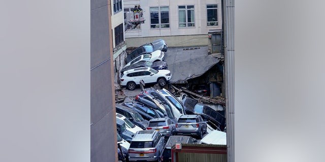 Firefighters work at the scene of a partial collapse of a parking garage in the Financial District of New York, Tuesday, April 18, 2023.