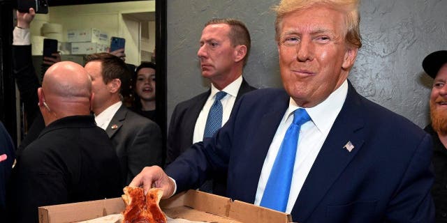 Former President Donald Trump eats a slice of pizza in Florida