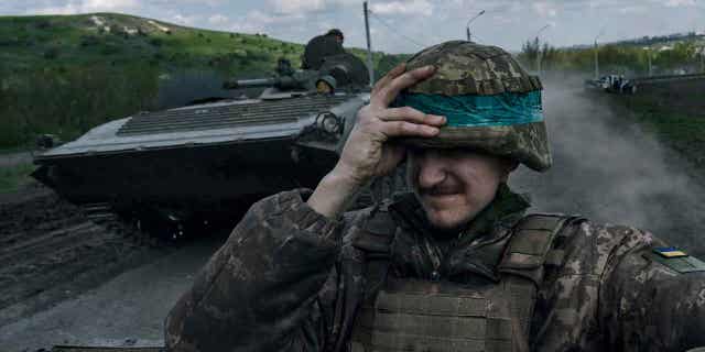 A Ukrainian soldier holds his helmet 