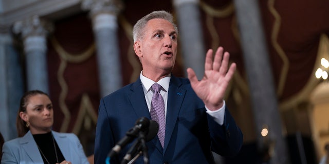 Speaker of the House Kevin McCarthy speaks with a raised hand