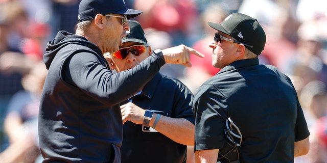Aaron Boone, left, of the New York Yankees argues a review call with home plate umpires Chris Guccione, right, and Larry Vanover after being ejected from a game during the first inning at Progressive Field April 12, 2023, in Cleveland.