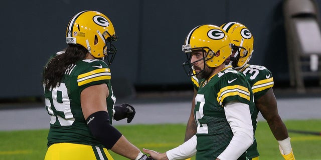 Aaron Rodgers (12) of the Green Bay Packers greets David Bakhtiari (69) prior to a game against the Chicago Bears at Lambeau Field Nov. 29, 2020, in Green Bay, Wis. 