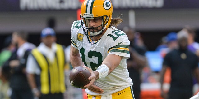 Aaron Rodgers hands over the ball