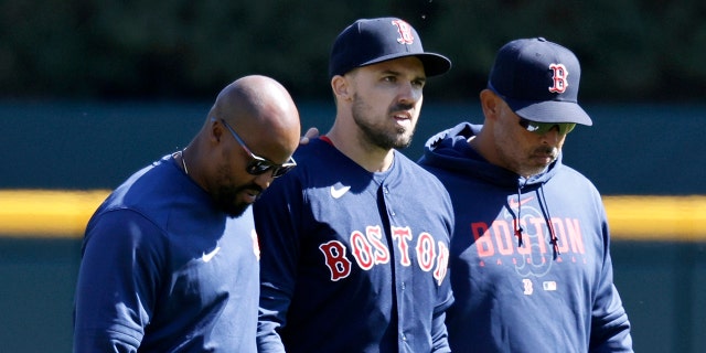 Adam Duvall #18 of the Boston Red Sox, center, leaves the game against the Detroit Tigers with manager Alex Cora #21 and a trainer after injuring his wrist while attempting a sliding catch during the ninth inning of the game at Comerica Park on April 9, 2023, in Detroit, Michigan.