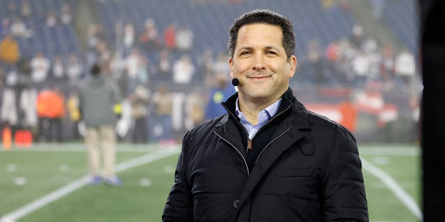 Adam Schefter smiles at podium