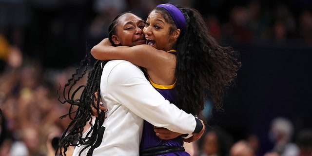 Angel Reese #10 of the LSU Lady Tigers celebrates with a teammate after defeating the Iowa Hawkeyes 102-85 during the 2023 NCAA Women's Basketball Tournament championship game at American Airlines Center on April 02, 2023 in Dallas, Texas.