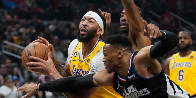 Los Angeles Lakers forward Anthony Davis, left, is defended by Los Angeles Clippers guard Russell Westbrook, #0, and forward Kawhi Leonard during the first half of an NBA basketball game Wednesday, April 5, 2023, in Los Angeles.