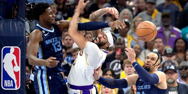 Los Angeles Lakers forward Anthony Davis (3), center, loses control of the ball between Memphis Grizzlies forwards Jaren Jackson Jr. (13) and Dillon Brooks (24) during Game 1 of a first-round NBA basketball playoff series Sunday, April 16, 2023, in Memphis, Tenn.