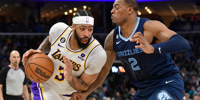 El alero de los Lakers de Los Ángeles, Anthony Davis (3), lucha contra el alero de los Grizzlies de Memphis, Xavier Tillman (2), en el Juego 1 de una serie de playoffs de baloncesto de la NBA en la primera ronda, el domingo 16 de abril de 2023, en Memphis, Tennessee.