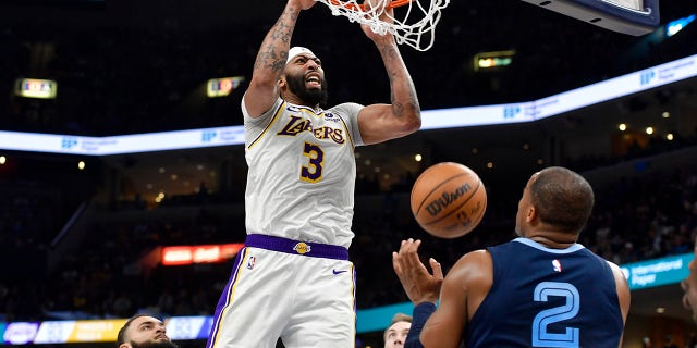 El alero de los Lakers de Los Ángeles, Anthony Davis (3), clava contra el alero de los Grizzlies de Memphis, Xavier Tillman (2), en el Juego 1 de una serie de playoffs de baloncesto de la NBA en la primera ronda el domingo 16 de abril de 2023 en Memphis, TN.