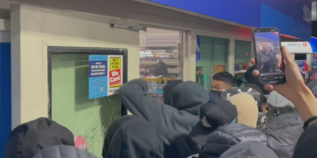 Unidentified people are seen early Sunday, April 16 breaking into an Arco gas station convenience store in Compton, California.