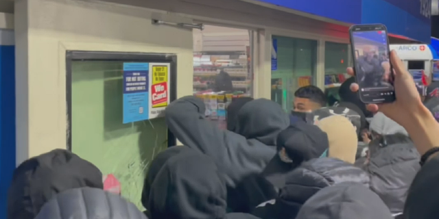 Unidentified people are seen early Sunday, April 16 breaking into an Arco gas station convenience store in Compton, California.