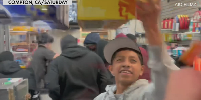 A man is seen taking packages of condoms inside the Arco store in Compton, California, early Sunday.