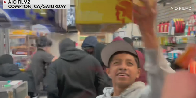 A man is seen taking packages of condoms inside the Arco store in Compton, California, early Sunday.