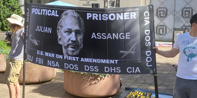 Supporters of Julian Assange hold a sign in support of the Wikileaks founder at a rally at the Justice Department.