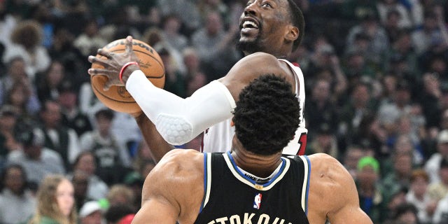 16 de abril de 2023;  Milwaukee, Wisconsin, EE. UU.;  El centro de Miami Heat, Bam Adebayo (13), aborda al alero de Milwaukee Bucks, Giannis Antetokounmpo (34), en la primera mitad durante el Juego 1 de los Playoffs de la NBA de 2023 en Fiserv Forum.