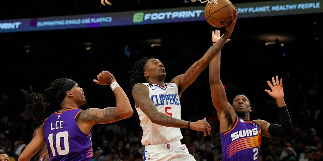 Los Angeles Clippers' Bones Hyland drives between the Suns' Damion Lee and Josh Okogie, Sunday, April 9, 2023, in Phoenix.