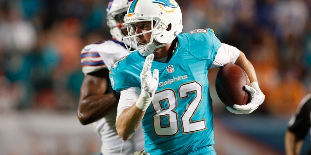 El receptor abierto #82 de los Miami Dolphins, Brian Hartline, corre con el balón contra los Buffalo Bills en el Sun Life Stadium el 13 de noviembre de 2014 en Miami Gardens, Florida.