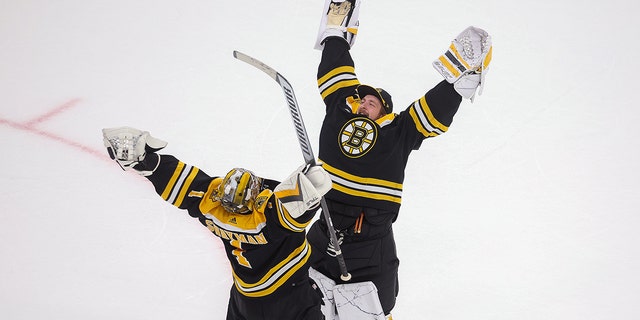 Boston Bruins goalies Jeremy Swayman, left, and Linus Ullmark celebrate a win over the Toronto Maple Leafs, 2-1, in overtime.