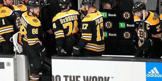 Bruins players walk off the ice