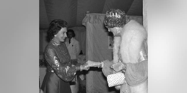 Nữ hoàng Anh Elizabeth II, trái, bắt tay Barry Humphries Dame Edna Everage