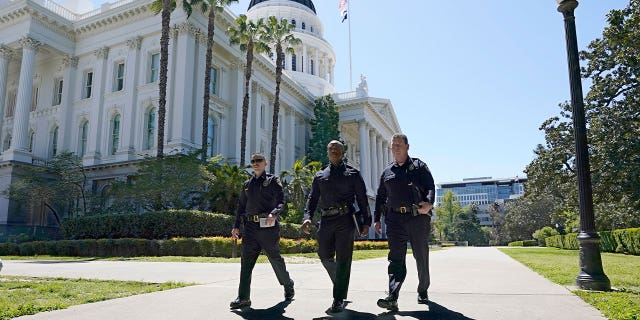 Police walk past California’s Capitol where a "credible threat" was made in Sacramento on April 13, 2023.