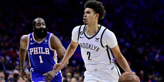 Brooklyn Nets' Cameron Johnson, right, dribbles past Philadelphia 76ers' James Harden in the first half during Game 2 in the first round of the NBA basketball playoffs, Monday, April 17, 2023, in Philadelphia. 