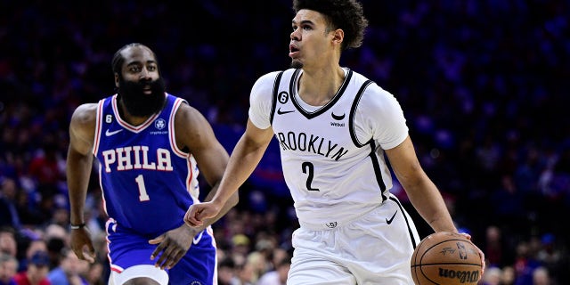 Brooklyn Nets' Cameron Johnson, right, dribbles past Philadelphia 76ers' James Harden in the first half during Game 2 in the first round of the NBA basketball playoffs, Monday, April 17, 2023, in Philadelphia.