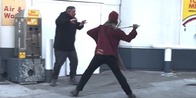 A man swings a pipe at another man outside a gas station