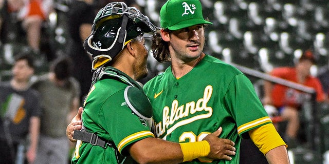 Relief pitcher Chad Smith is congratulated by catcher Carlos Perez at the end of the Oakland Athletics' victory over the Orioles on April 12, 2023 in Baltimore.