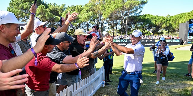 Aficionados de Chase Koepka chocando los cinco