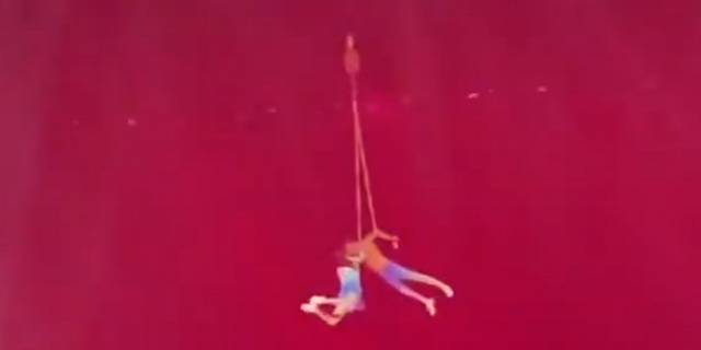 Chinese acrobat dangling in the air