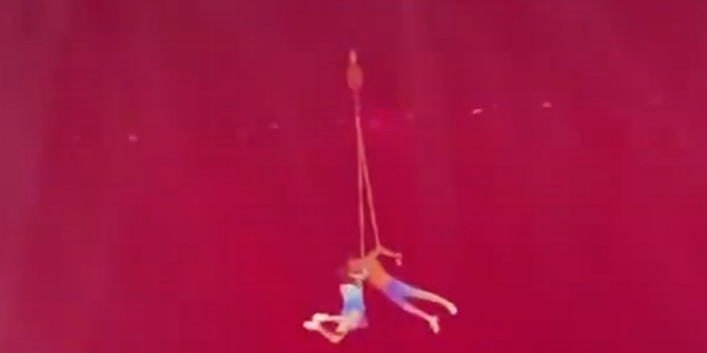 Chinese acrobat dangling in the air