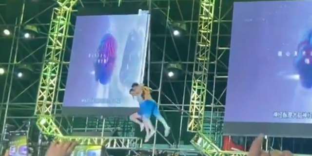 Chinese acrobat couple lifted off the ground