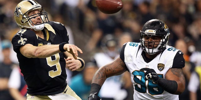 Drew Brees of the Saints is pursued by Chris Smith of the Jacksonville Jaguars at the Mercedes-Benz Superdome on Dec. 27, 2015, in New Orleans.