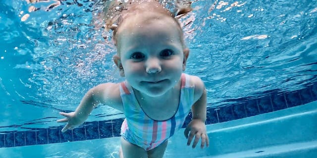 Claire Scarnati swims underwater with her mother, swim instructor Nikki Scarnati, nearby. Nikki Scarnati said she advises parents to use layers of protection when it comes to children and water safety.