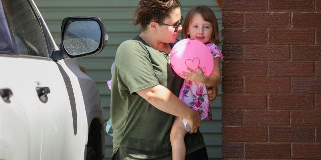 Cleo Smith, right, is carried inside a friend's house by her mother on Nov. 4, 2021 in Carnarvon, Australia.