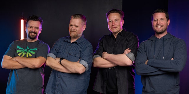 Elon Musk poses for a photo with the Babylon Bee's staff during a podcast interview in Dec. 2021.